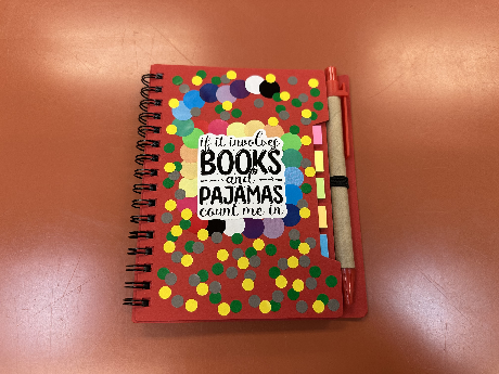 Red notebook with book saying sticker and multi-colored sticker dots