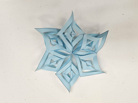 light blue paper snowflake on white background