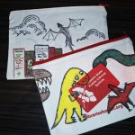Two pencil pouches decorated with dinosaurs and dragons