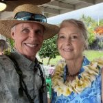 white man and woman standing outside wearing lei