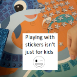 picture of dolphin with shiny stickers and stars being added by hand and text playing with stickers isn't just for kids and winking smiley face
