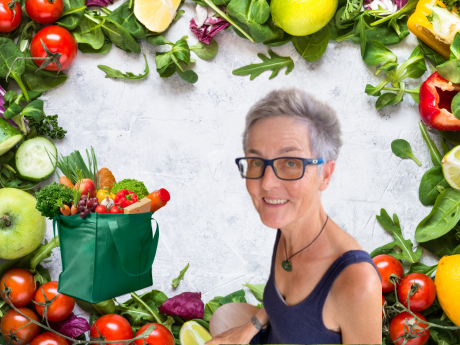 Fresh vegetables as a background with a woman in glasses in the foreground