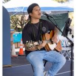 seated man playing guitar