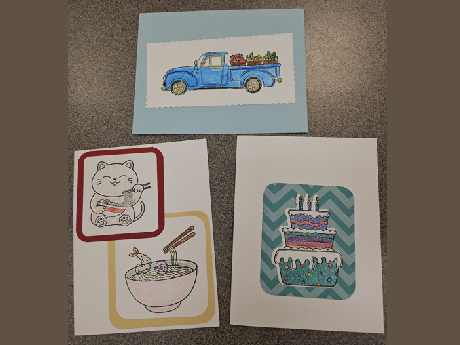 Three handmade cards, one with a truck and fruit, one with a cat eating saimin and a saimin bowl with chopsticks, and one with a birthday cake with a blue background