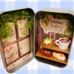A candy tin with miniature bakery items inside