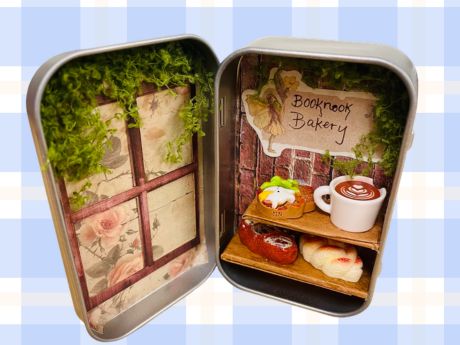 A candy tin with miniature bakery items inside