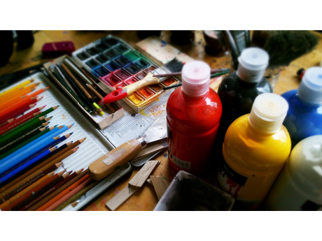 art supplies including colored pencils and paints on a table
