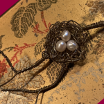 wire worked bird's nest with pearls on japanese pattern background