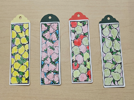 Four bookmarks with lemons, strawberries, apples, and pears colored with pencils