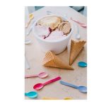 bowl of ice cream on a table with spoons and cones scattered around