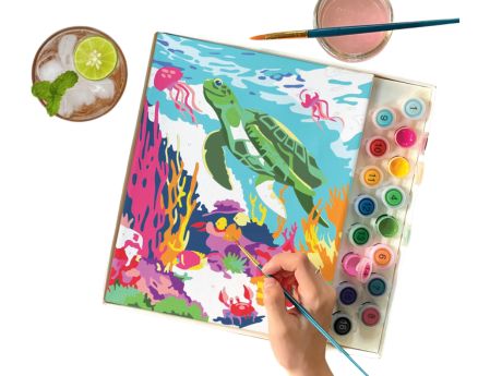 paint by numbers image, hand with paintbrush, paint, top view of a drink with ice and lime