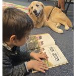 Boy reading to a therapy dog