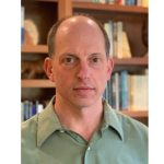 John Kruse picture with book shelf in the back