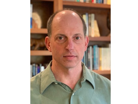 John Kruse picture with book shelf in the back