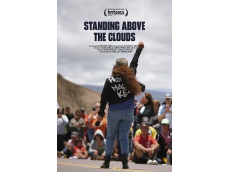 Documentary poster reading “Standing Above the Clouds,” showing a young person raising a fist before a mountain crowd, conveying pride and resilience.
