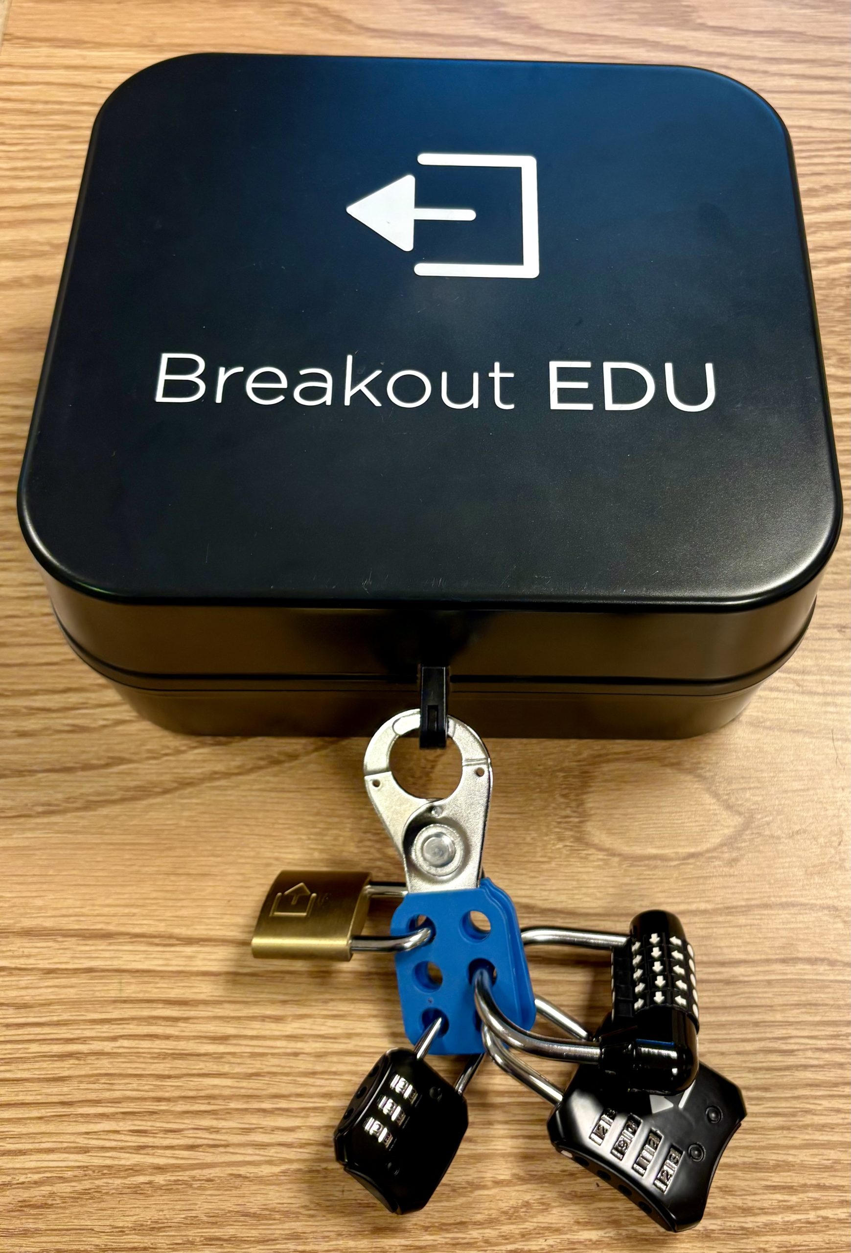 Photo of black metal box locked with a hasp and several combination locks.