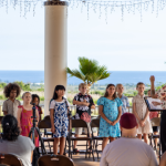 children standing and singing in a group outside.